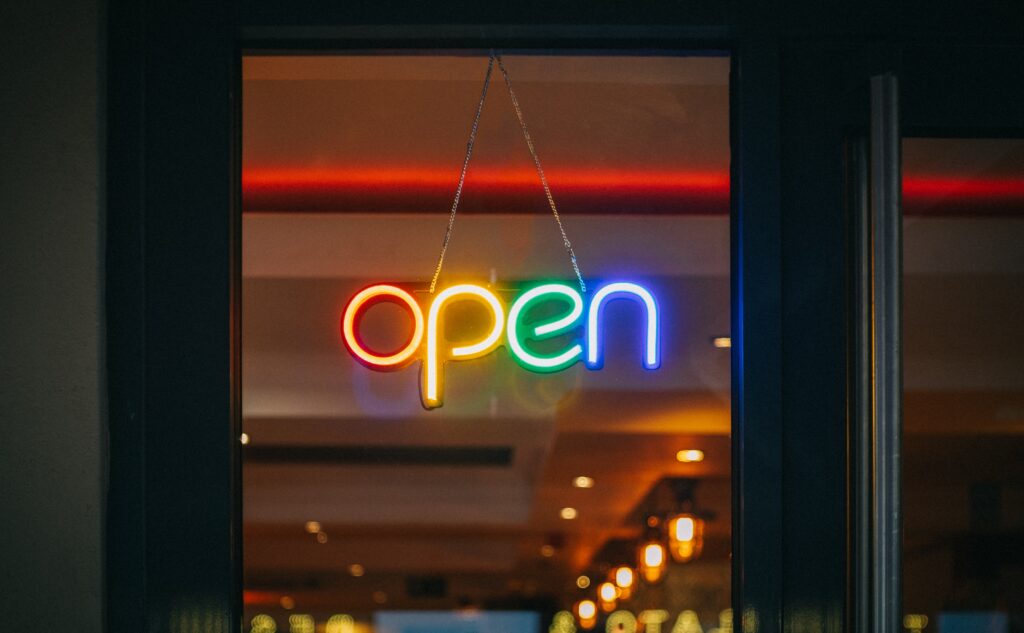 Titelbild Blogbeitrag: Barrierefreiheit-Zugänge für alle. Fotografie eines Leuchtschildes mit dem Schriftzug "open"